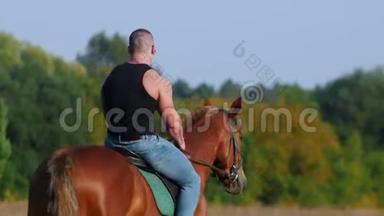 强壮的肌肉男，穿着黑色t恤和太阳镜，骑着马在田野里，<strong>远离</strong>相机
